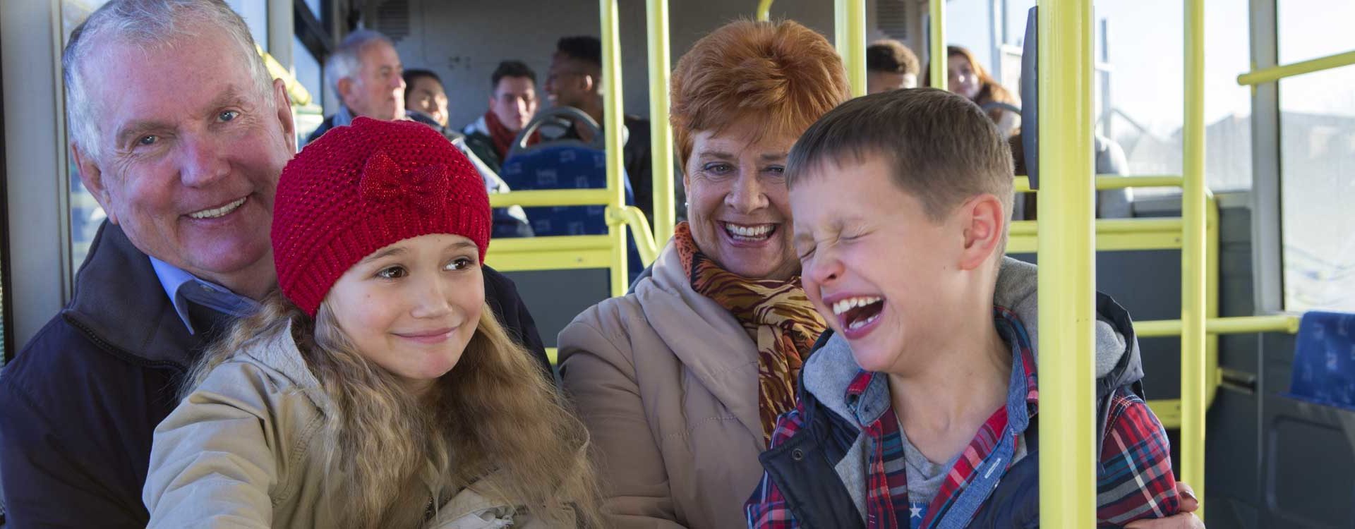 Grands-parents et petits-enfants souriant en transport en commun